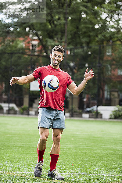 Ein Mann spielt Fußball auf einem Feld im Stadtpark