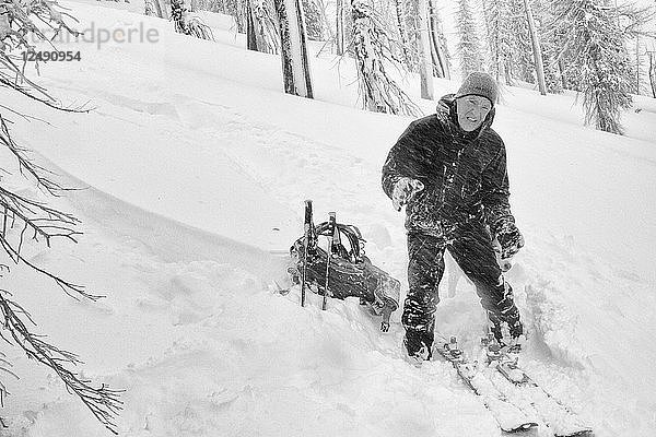 Ein Skitourengeher leidet unter dem stürmischen Wind und den kalten Temperaturen während der Umstellung in den Bitterroot Mountains bei Victor  Montana.