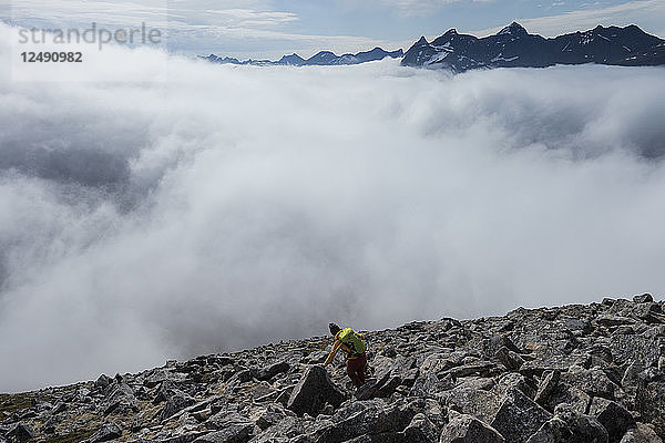 Wanderin bei bewölktem Wetter beim Abstieg vom Gipfel des Volandstind  Lofoten  Norwegen