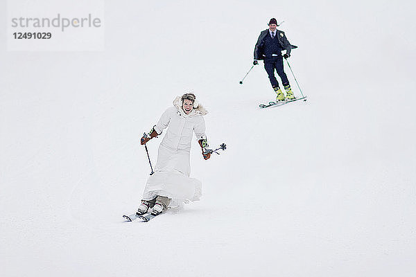 Ein frisch verheiratetes Paar fährt nach der Hochzeit gemeinsam einen Berg hinunter.