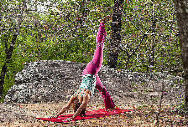 Frau übt Yoga im Wald