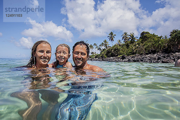 Eine Familie amüsiert sich in der Waimea Bay an der Nordküste von Oahu