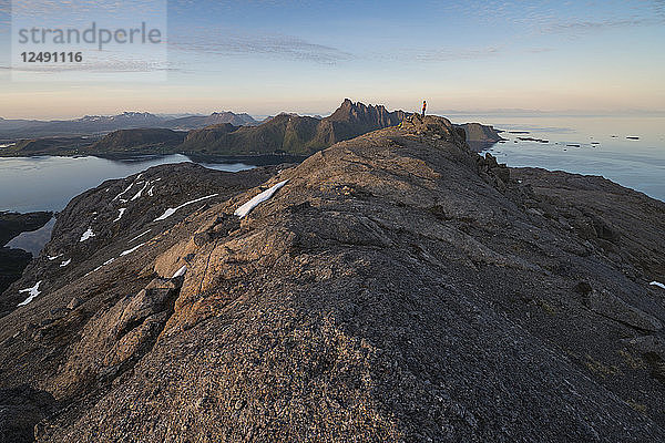 Wanderin steht auf dem Gipfel des Berges Hestr?¶va  Flakstad??y  Lofoten Inseln  Norwegen