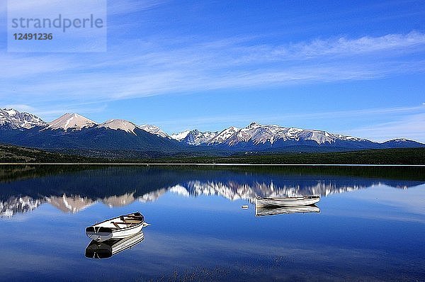 Zwei leere Boote auf dem See von Tres Valles  Argentinien. Dünne Wolken und schöne Bergketten sorgen für eine schöne Szene.