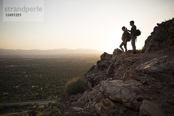 Ein junges schwangeres Paar wandert bei Sonnenuntergang über Salt Lake City  Utah.
