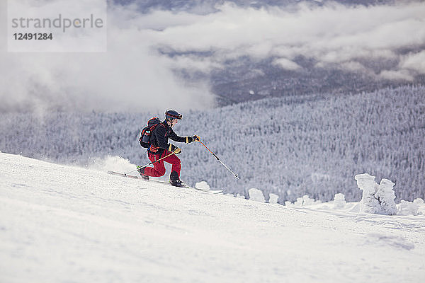 Ein Skitourengeher fährt auf den Schneefeldern am Burnt Mountain in Maine.