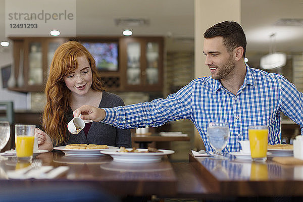 Ein nettes junges Paar genießt Snacks und Fruchtsaft in einer Cafeteria.