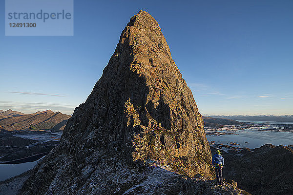 Bergsteigerin betrachtet die Route zum Gipfel der Reka  Vester?-len  Norwegen