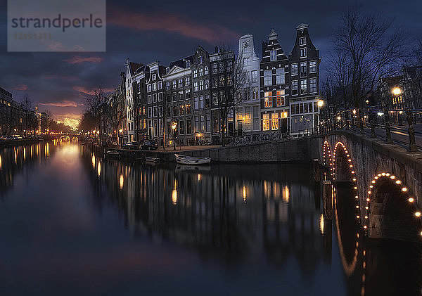 Beleuchtete Brücke über den Fluss in Amsterdam