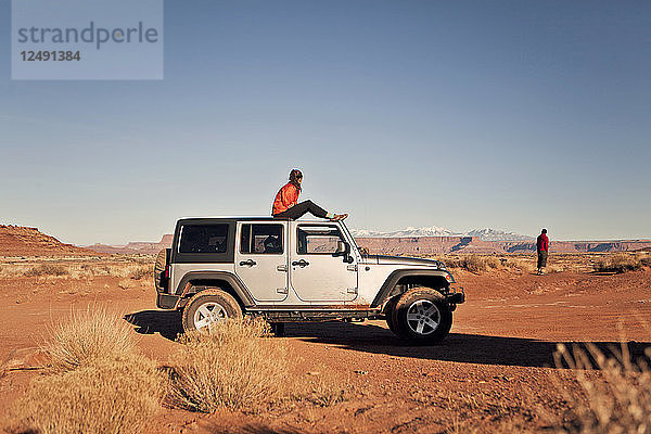Zwei Reisende genießen die Aussicht aus ihrem Jeep beim Off-Road-Fahren im Canyonlands National Park