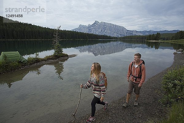 Junges Paar wandert am Bergsee entlang