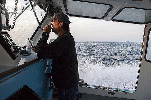 Ein Fischer  der auf seinem Boot über Funk spricht