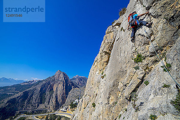 Ein Mann klettert im Vorstieg eine Route in der Sierra de Toix in Spanien.