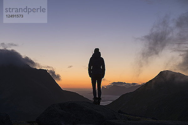 Silhouette einer Wanderin in der Dämmerung um 3:00 Uhr im Spätsommer  Moskenes??y  Lofoten  Norwegen