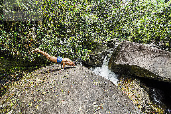 Mann in Pfauenpose am Fluss Pirapetinga im Naturschutzgebiet Serrinha do Alambari  Rio de Janeiro  Brasilien