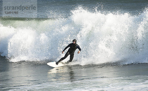 Surfer im Neoprenanzug auf einer Welle