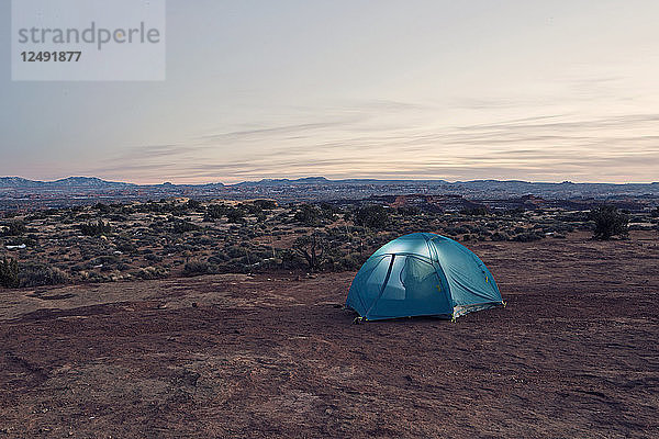 Ein Zelt leuchtet in der Dämmerung tief im Hinterland des Canyonlands National Park.