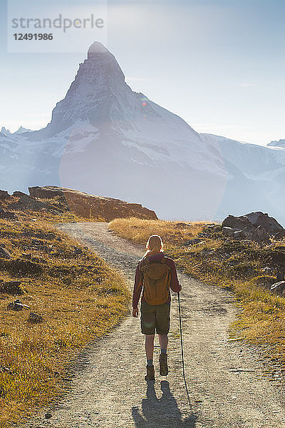 Weiblicher Wanderer geht vor dem berühmten Matterhorn