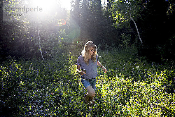 Eine junge Frau in einem Wald mit einer Kamera