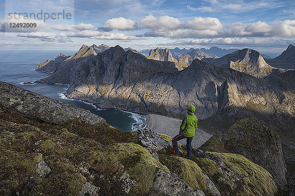 Wanderin genießt die Aussicht auf den Strand von Bunes bei einer Wanderung zum Gipfel der Storskiva  Moskenes??y  Lofoten  Norwegen