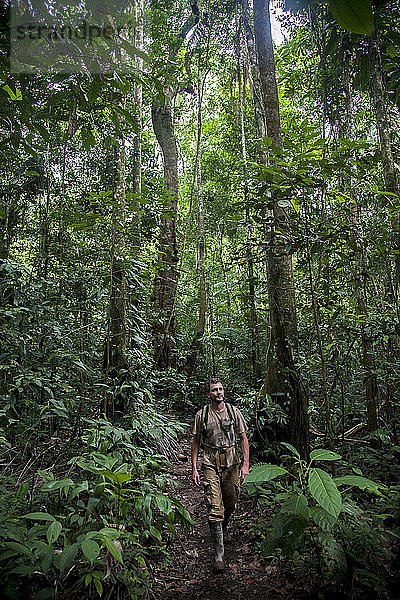 Ein Mann wandert durch den peruanischen Amazonasdschungel.