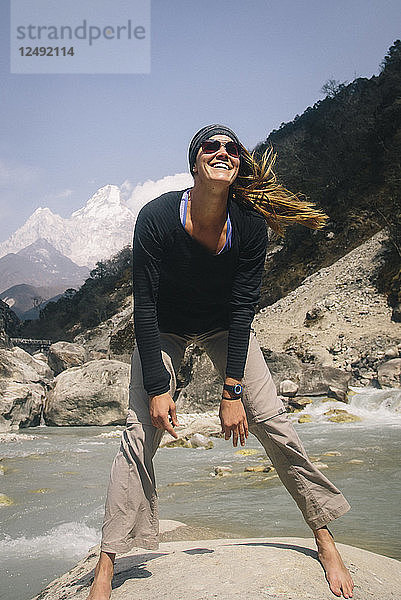 Eine Frau lächelt am Wegesrand auf dem Weg zum Everest Base Camp