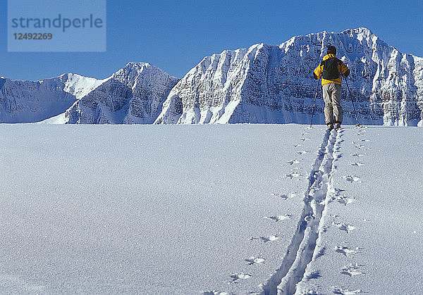 Skifahrer geht durch Schnee in den Bergen