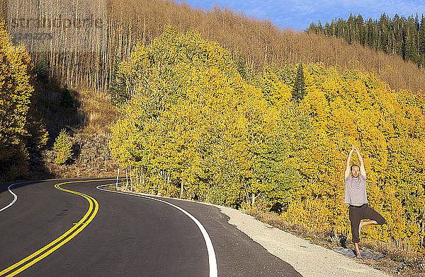 Ein Mann macht Yoga an einem Herbsttag im Big Cottonwood Canyon in Utah.