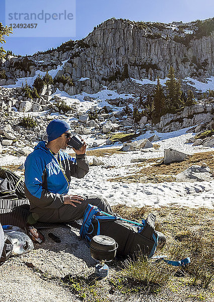 Ein Mann kocht Frühstück und genießt seinen Kaffee beim Camping in der Lone Peak Wilderness in Utahs Wasatch Mountains