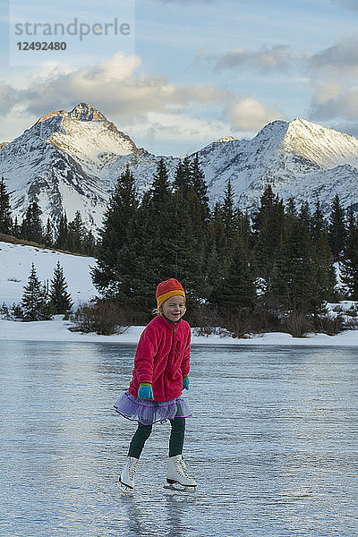 Ein Mädchen beim Schlittschuhlaufen auf dem Eis der Vorsaison  Molas Lake  San Juan National Forest  Silverton  Colorado.