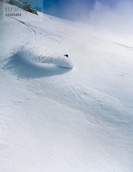 Eine Snowboarderin macht eine Kurve im Tiefschnee am Cerro Catedral  Argentinien
