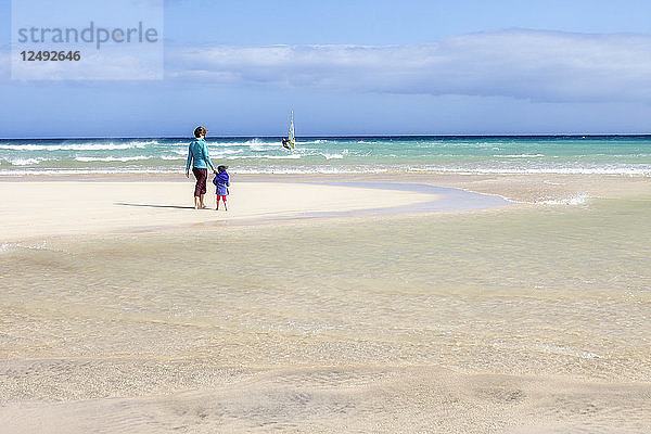 Mutter und Tochter stehend am Strand von Sotovento  Spanien