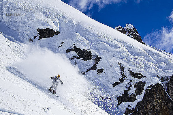Ein Snowboarder zerschneidet Pulverschnee im Hinterland des Cerro Catedral in Argentinien