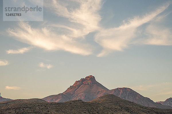 Bergkette in der Ferne unter einem sanft leuchtenden Morgenhimmel