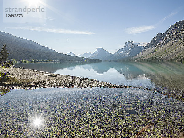 Spiegelung von Bergen und Sonne im Bow Lake