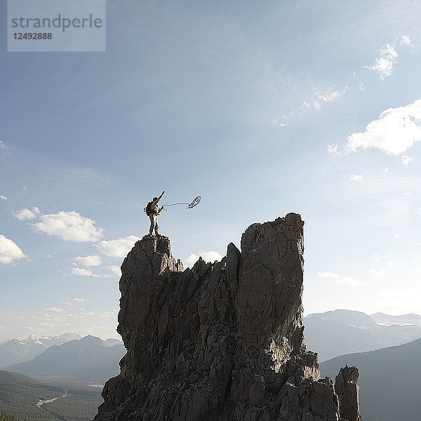 Bergsteiger wirft Seil  Berggipfel