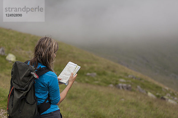 Wanderin konsultiert Karte zur Orientierung