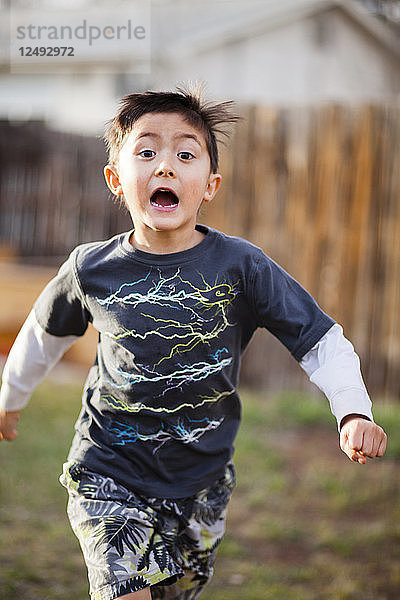 Ein 6-jähriger japanisch-amerikanischer Junge rennt durch den Hinterhof.