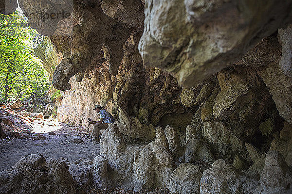 Älterer Herr sitzt in der Nähe der Höhle an der Grotte im Mckittrick Canyon