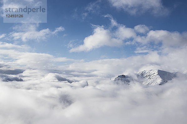 Der Gipfel eines schneebedeckten Berges ragt über die Wolken in Bariloche  Argentinien  USA