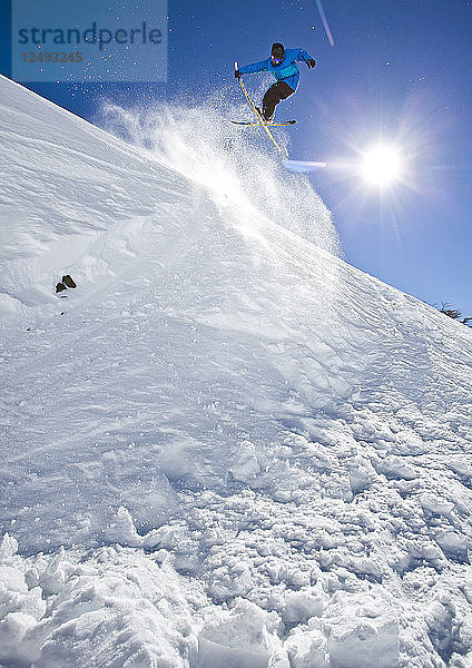 Ein Skifahrer trifft eine Schanze und schnappt sich die Skier beim Skifahren am Cerro Catedral  Argentinien