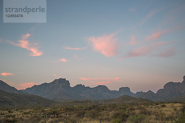 Eine Bergkette in der Ferne unter einem sanft leuchtenden Morgenhimmel