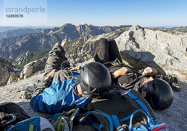 Zwei Männer ruhen sich auf dem Gipfel des Lone Peak nach einem langen  anstrengenden Aufstieg auf der Kletterroute Open Book in den Wasatch Mountains von Utah aus.