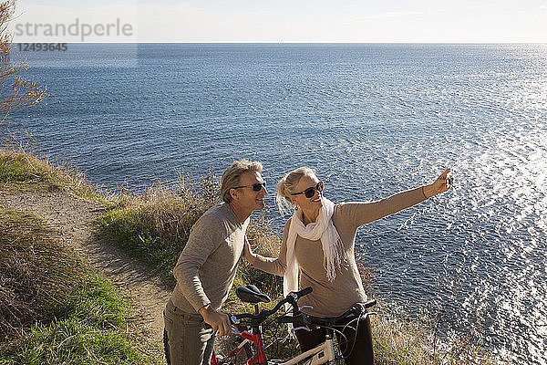 Pärchen mit Fahrrädern machen Selfie über dem Meer