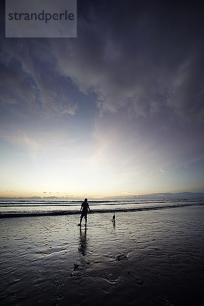 Sonnenaufgang Menschen  die am Strand spazieren gehen.Indonesien Bali Kuta