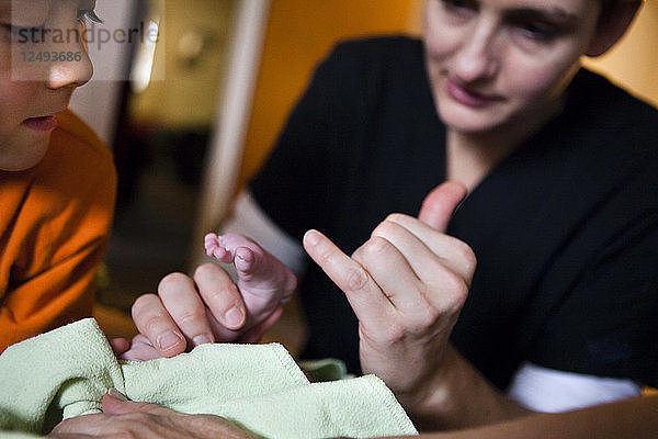 Hebamme führt Vitalzeichen auf neugeborenes Baby Girl überprüft