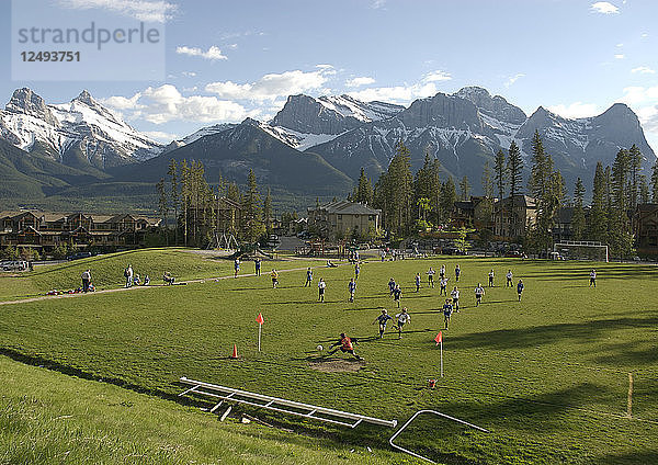 Luftaufnahme von Fußball spielenden Kindern auf einem Feld in den Bergen