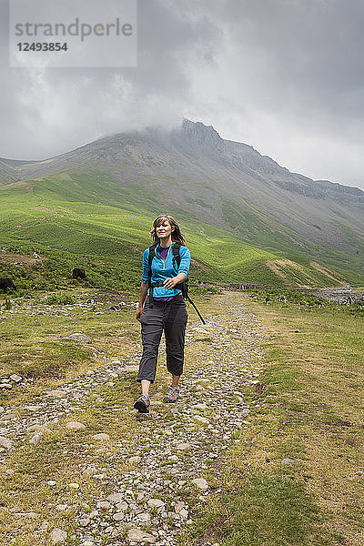 Wanderin wandert auf einem Kopfsteinpflasterweg