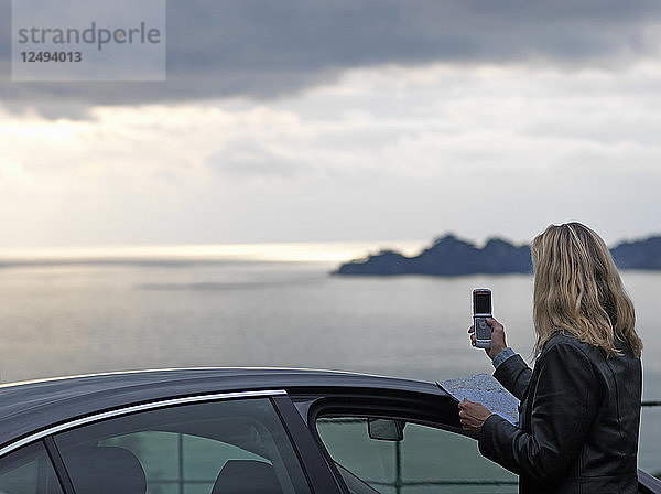 Frau fotografiert mit Handy ruhige See