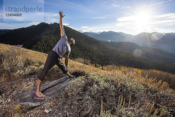Ein Mann macht Yoga an einem Herbsttag im Big Cottonwood Canyon in Utah.